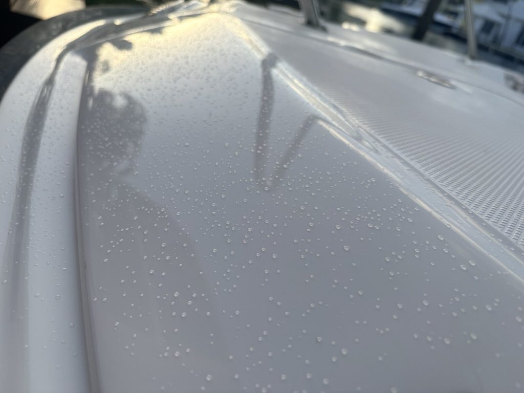 Water droplets across a white boat surface
